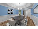 Formal dining area with decorative wainscoting, modern lighting, and seating for eight at 2913 Coxindale Dr, Raleigh, NC 27615