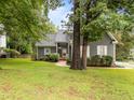 Charming gray home with lush lawn and mature trees nestled in a serene neighborhood at 2913 Coxindale Dr, Raleigh, NC 27615