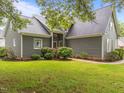 Inviting home exterior showcasing lush landscaping, stone walkway, and gray vinyl siding at 2913 Coxindale Dr, Raleigh, NC 27615