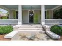 Inviting front porch with gray flooring, white railings, and a dark door with green shutters at 308 W Whitaker Mill Rd, Raleigh, NC 27608