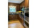 Kitchen features dark wood cabinets, black countertops, and stainless steel appliances, including a Viking oven at 3298 Oakridge Dr # A, Graham, NC 27253