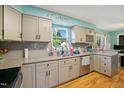 Featuring a double sink, granite countertops, stainless steel appliances and grey cabinets at 3712 Old Coach Rd, Raleigh, NC 27616