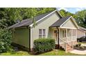 An exterior view of a charming home with light green siding and mature landscaping at 413 Top Greene Ln, Raleigh, NC 27601