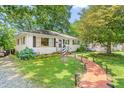 Charming single-story home with lush landscaping and a brick walkway at 422 Hyde St, Burlington, NC 27217