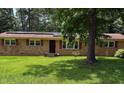 Inviting brick home with red shutters, black front door, and well-manicured lawn at 4618 Blanchard Rd, Durham, NC 27713