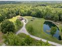Aerial view of log home, pond, acreage, and winding driveway at 4659 Antioch Rd, Oxford, NC 27565