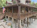 Close-up of log home with porch, stone accents, and manicured landscaping at 4659 Antioch Rd, Oxford, NC 27565