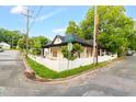 Corner lot featuring a renovated home with a white picket fence, lush landscaping, and charming curb appeal at 516 Ottawa Ave, Durham, NC 27701
