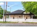 Charming single-story home with a black roof, white siding, picket fence, and inviting front porch at 516 Ottawa Ave, Durham, NC 27701