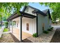 A side angle of a home shows a black roof, a porch, and new gravel landscaping at 516 Ottawa Ave, Durham, NC 27701