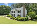 Side view of a two-story home featuring manicured landscaping, a chimney, and a glimpse of a backyard pool at 5301 Night Heron Dr, Wake Forest, NC 27587