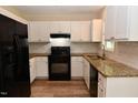 Modern kitchen with white cabinets, granite countertops, and stainless steel appliances at 5949 Sandy Run, Knightdale, NC 27545