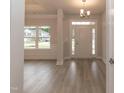 Bright foyer featuring wood-look floors, elegant wainscoting, and a stylish chandelier at 61 River Chapel Dr, Fuquay Varina, NC 27526