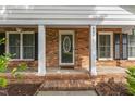 Close-up of the brick front porch with classic white columns and decorative front door at 6411 Pondview Ln, Durham, NC 27712