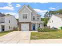 Charming two-story home with gray siding, brick accents, a well-manicured lawn, and a cozy front porch at 6512 Bunker Hill Dr, Raleigh, NC 27610
