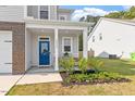 Inviting front porch with a bright blue door and lovely landscaping at 6512 Bunker Hill Dr, Raleigh, NC 27610