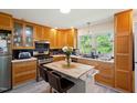 Bright kitchen with stainless steel appliances, custom cabinets, modern countertops and center island at 7 Woodward Way, Chapel Hill, NC 27516