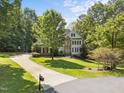 Spacious home with a long driveway, lush greenery, and a well-maintained lawn at 7000 Millstone Ridge Ct, Raleigh, NC 27614