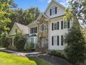 Beautiful two-story home showcasing stone accents, complemented by lush landscaping and mature trees at 7000 Millstone Ridge Ct, Raleigh, NC 27614