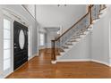 Bright foyer with hardwood floors, a staircase with wrought iron spindles, and a view to the living room at 7000 Millstone Ridge Ct, Raleigh, NC 27614
