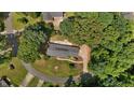 Aerial view of a single-story brick home with solar panels, surrounded by mature trees at 825 Whispering Wind Rd, Burlington, NC 27217