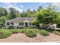 Charming single-story home with black shutters, wrought iron fence and lush landscaping at 877 Millcroft, Pittsboro, NC 27312