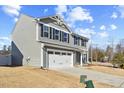 Side view of a gray two-story home with a white garage door on a sunny day at 1004 Bridgewater Dr, Durham, NC 27704