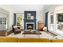 Cozy living room with a fireplace, hardwood floors, and large windows at 103 Saint Brides Ct, Cary, NC 27518