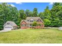 Stunning brick home with lush green lawn and mature trees in a serene setting at 1084 Wild Briar Ln, Stem, NC 27581