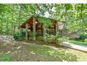 Exterior shot of a unique home design with stone pillars, wooden siding, and lush greenery at 110 Wolfs Trl, Chapel Hill, NC 27516