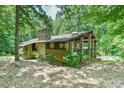 Exterior of a wooded cabin retreat with a stone chimney and wood facade at 110 Wolfs Trl, Chapel Hill, NC 27516