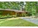 Front exterior showcasing a stone accented home with a sprawling driveway at 110 Wolfs Trl, Chapel Hill, NC 27516