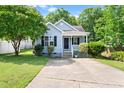 Lovely blue single-story home with black shutters, landscaped front yard, and concrete driveway under a partly cloudy sky at 1138 Ricochet Dr, Raleigh, NC 27610
