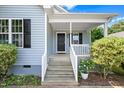 Close-up of the inviting light blue home entrance with a well-maintained front porch with white railings at 1138 Ricochet Dr, Raleigh, NC 27610