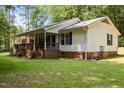 Charming single-story home with brick foundation, cozy front porch, lush lawn, and mature trees at 117 Lema Dr, Garner, NC 27529