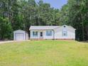 Charming single-story home featuring blue shutters, white siding, and a spacious front yard at 117 Renee Dr, Smithfield, NC 27577