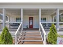Inviting front porch with comfortable seating and a charming red front door with welcoming decor at 1230 S 2Nd St, Smithfield, NC 27577