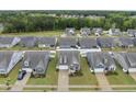 Aerial view of a residential neighborhood, showcasing similar homes with well-kept lawns and landscaping at 129 Alumroot Rd, Holly Springs, NC 27540