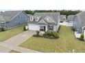 Charming home with a well-manicured lawn, inviting porch and an attached two-car garage at 129 Alumroot Rd, Holly Springs, NC 27540