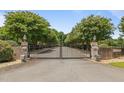 Grand gated entrance to Winding Creek Farm, lined with mature trees and brick pillars at 1624 Hopkins Rd, Bahama, NC 27503