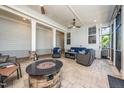 Covered outdoor patio featuring a stone fireplace, comfortable seating, and ceiling fans for added relaxation at 1705 Main Divide Dr, Wake Forest, NC 27587