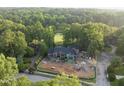 Aerial view of modern home featuring brick and green sheathing, surrounded by mature trees at 1925 Hunting Ridge Rd, Raleigh, NC 27615