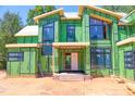Close-up of a modern home's facade under construction, showcasing large windows and unique design elements at 1925 Hunting Ridge Rd, Raleigh, NC 27615