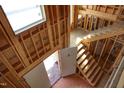 Interior framing of a home featuring staircase and windows, awaiting completion and customization at 1925 Hunting Ridge Rd, Raleigh, NC 27615