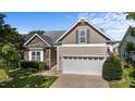 Attractive exterior featuring stone accents, a two-car garage, landscaped yard, and a clear sky at 2117 Crockett Ridge Rd, Fuquay Varina, NC 27526