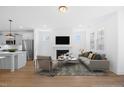 Bright, open-concept living room featuring a fireplace, modern furnishings and an adjacent kitchen with stainless steel appliances at 212 Aubey Ln, Wake Forest, NC 27587