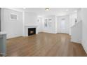 Bright living room featuring hardwood floors, fireplace, and access to other living areas at 212 Aubey Ln, Wake Forest, NC 27587