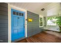 Inviting front porch with a blue door, yellow mailbox and a comfortable porch swing at 218 Lafayette Rd, Raleigh, NC 27604