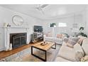 Bright living room with a fireplace, hardwood floors, and neutral furnishings at 218 Lafayette Rd, Raleigh, NC 27604