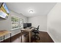 Bright home office featuring hardwood floors, a large window, and a modern desk setup at 2412 Averon Dr, Fuquay Varina, NC 27526